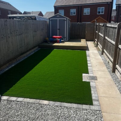Rear garden landscaping with lawn and patio area